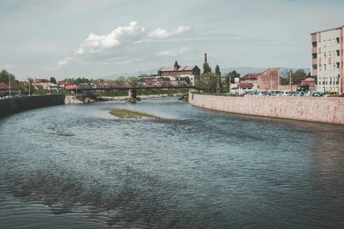 Reka između kamenih obala, čelični most i zgrade u pozadini, Niš