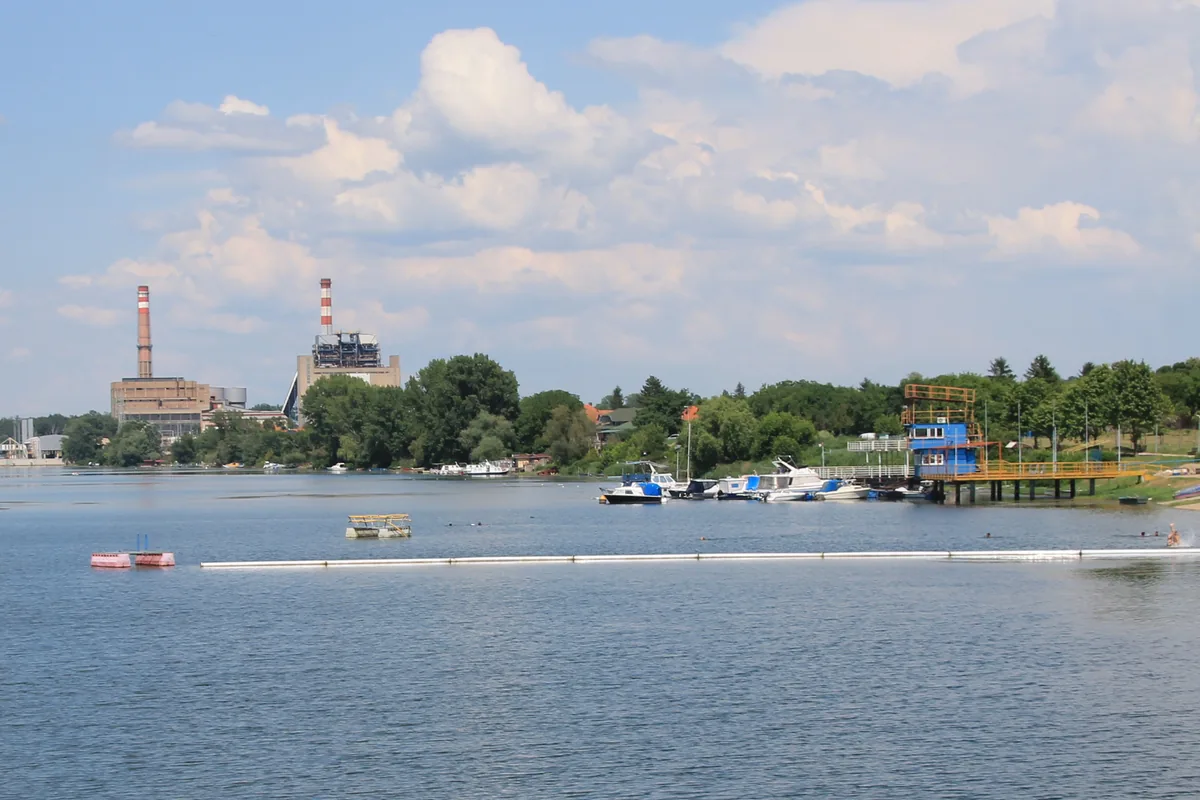 Rukavac Dunavac u Kostolcu sa gradskom plažom, čamcima i dimnjacima termoelektrane u pozadini