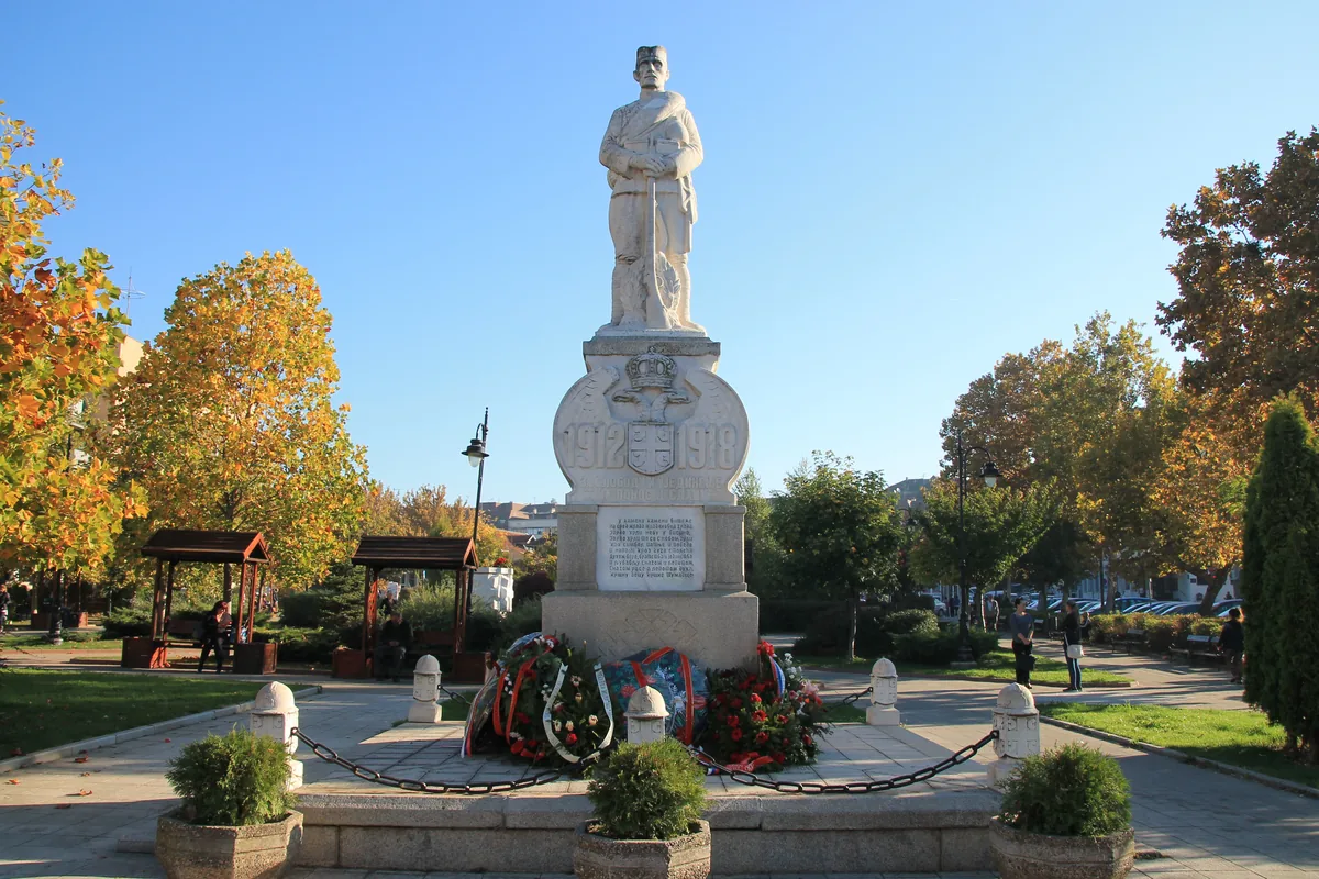 Spomenik palim ratnicima 1912–1918. sa kamenom figurom vojnika u parku u centru Mladenovca, jesen