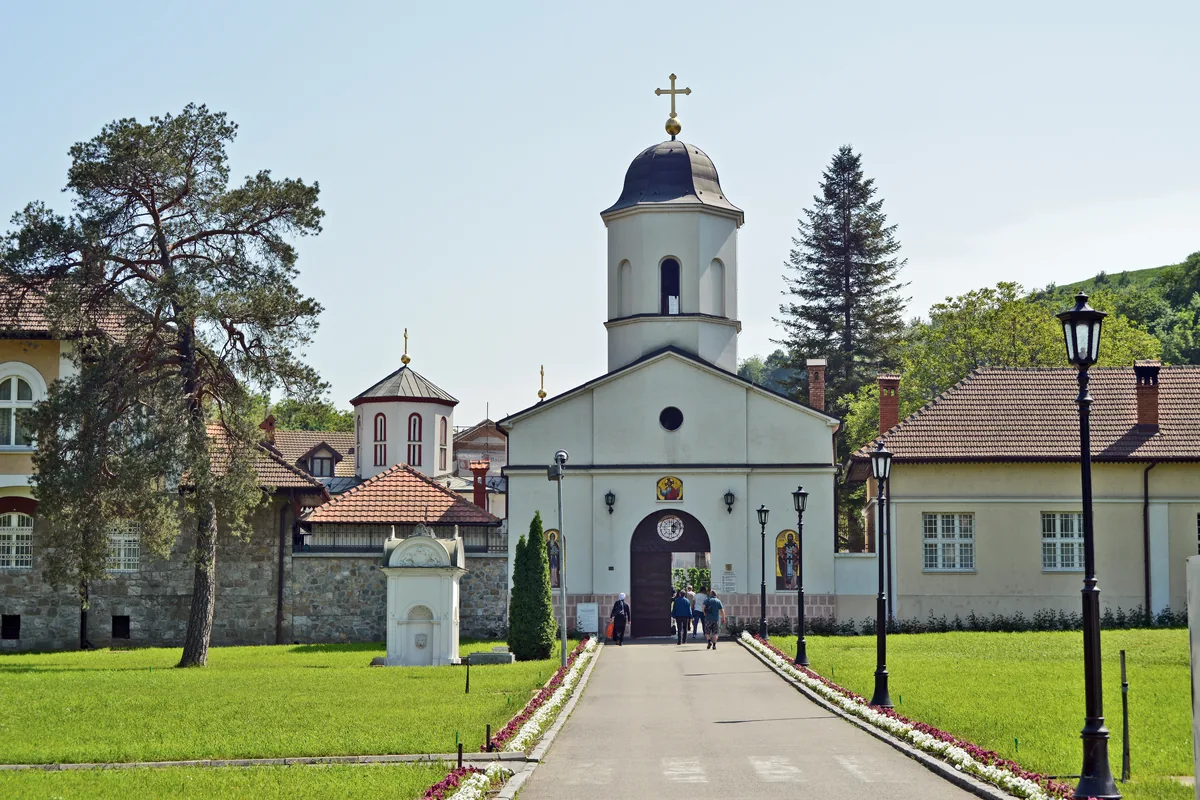 Crkva manastira Rakovica sa zvonikom, konacima i alejom kroz travnjak